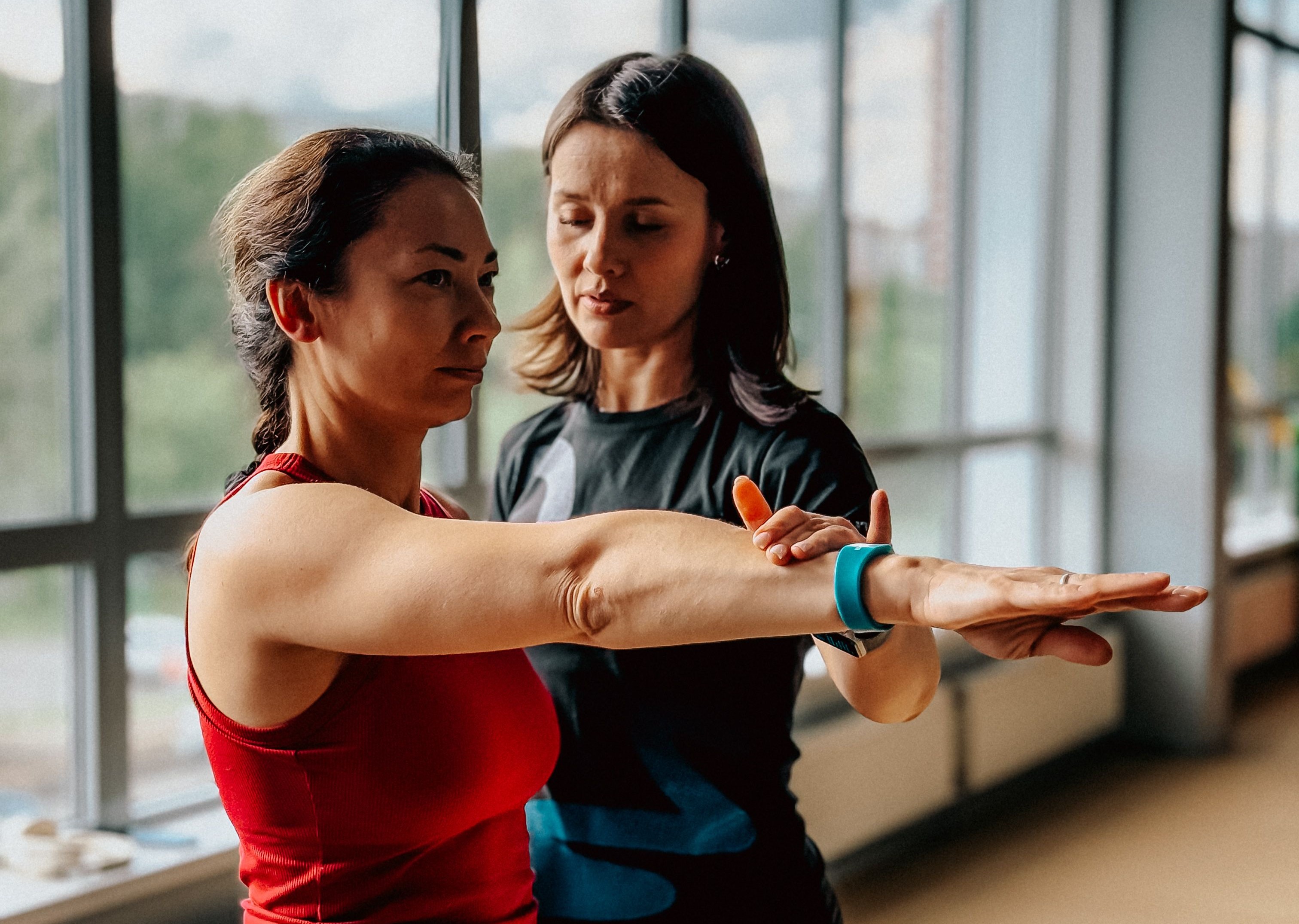 Entrenadora ayudando a una mujer hacer ejercicio en un gimnasio